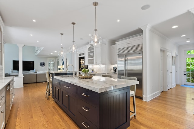 249 Sturges Hwy, Westport, CT 06880 - kitchen featuring stainless steel appliances, a sink, a kitchen bar, white cabinetry, and ornamental molding