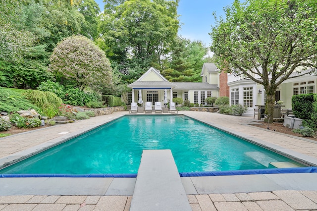 249 Sturges Hwy, Westport, CT 06880 - swimming pool with an exterior structure, a patio area, an outbuilding, a diving board, and french doors