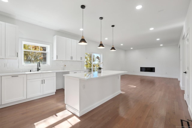 19A Apache Dr, Brookfield, CT 06804 - kitchen featuring a sink, light wood-style flooring, a fireplace, tasteful backsplash, and a center island