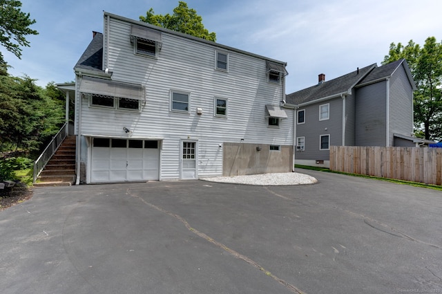 394 Mcclintock St, New Britain, CT 06053 - back of property featuring an attached garage and asphalt driveway