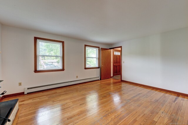 394 Mcclintock St, New Britain, CT 06053 - unfurnished living room featuring baseboard heating, healthy amount of natural light, light wood finished floors, and baseboards
