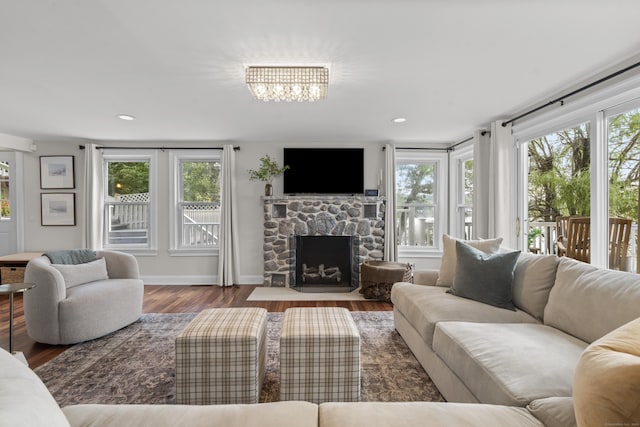 1795 Wolcott Rd, Wolcott, CT 06716 - living room with wood finished floors, a stone fireplace, a chandelier, and baseboards
