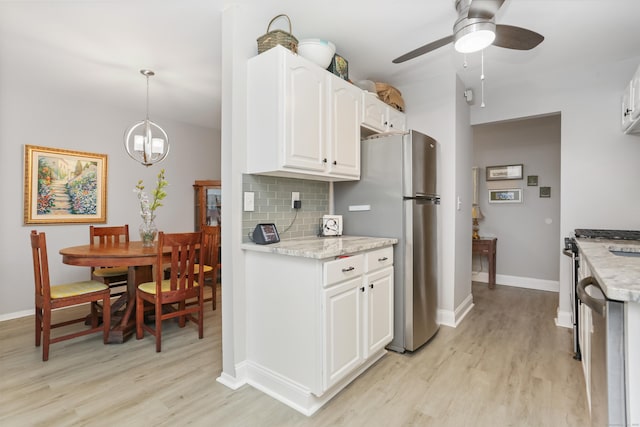 87 E Broadway Unit D, Milford, CT 06460 - kitchen with light wood-style flooring, appliances with stainless steel finishes, white cabinetry, and decorative backsplash