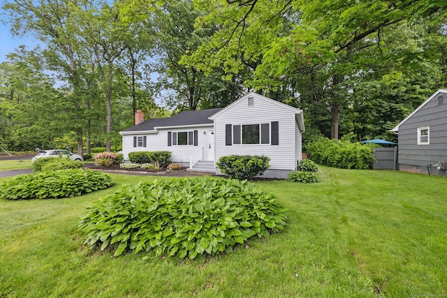 single story home with a chimney and a front yard