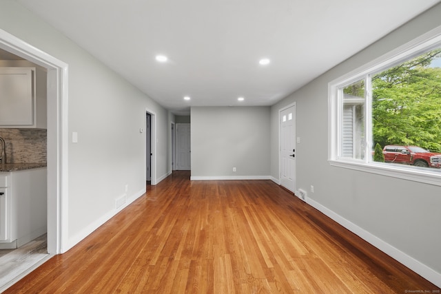 unfurnished room featuring recessed lighting, light wood-style floors, and baseboards