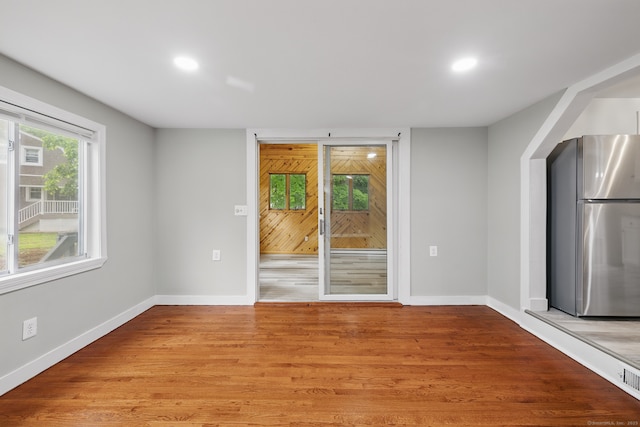 unfurnished dining area with baseboards, recessed lighting, and light wood-style floors
