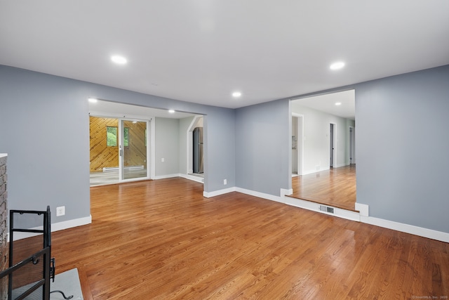 unfurnished room featuring recessed lighting, wood finished floors, and baseboards