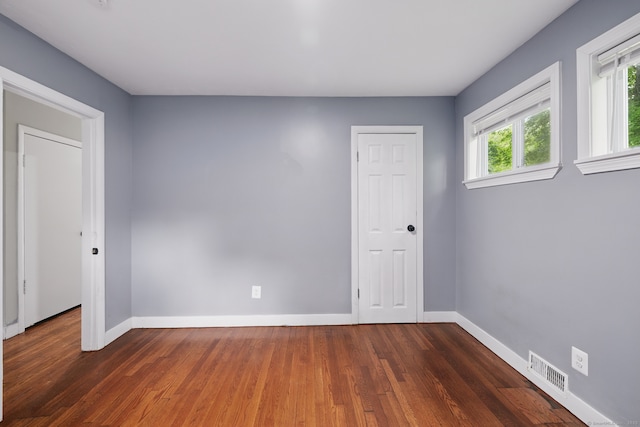 unfurnished room featuring baseboards and wood finished floors