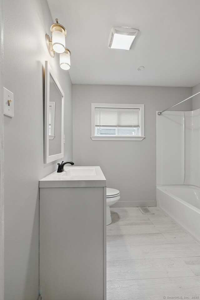 full bathroom featuring vanity, toilet, bathtub / shower combination, and baseboards