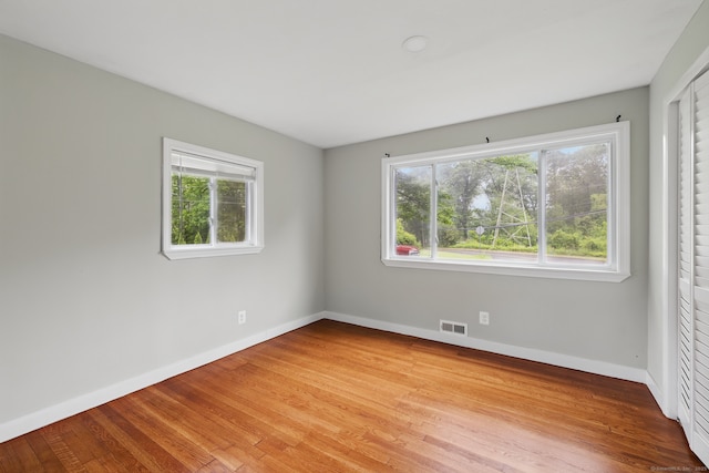 spare room featuring baseboards and light wood finished floors