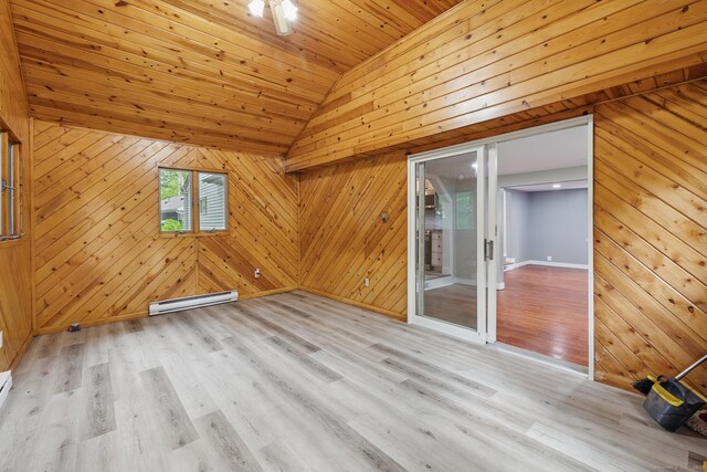 unfurnished room featuring a baseboard heating unit, wood walls, light wood-type flooring, vaulted ceiling, and wooden ceiling