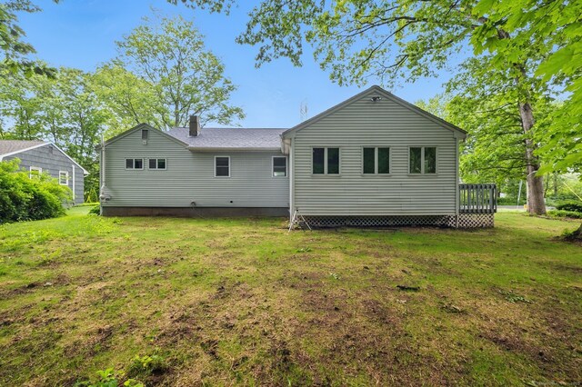 rear view of house featuring a yard and a chimney