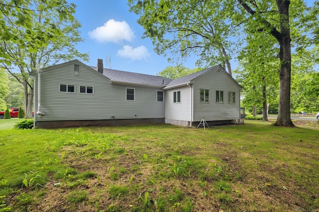 back of property featuring a yard and a chimney