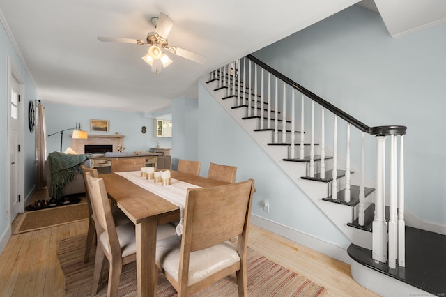 8 Maple Ave, Clinton, CT 06413 - dining space with wood finished floors, stairway, ceiling fan, a fireplace, and baseboards