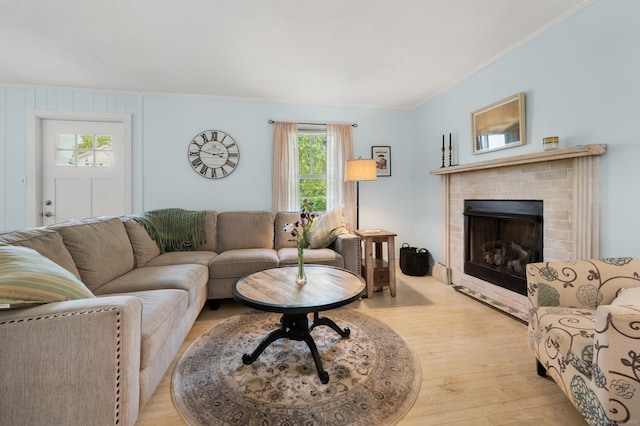 8 Maple Ave, Clinton, CT 06413 - living room with ornamental molding, wood finished floors, healthy amount of natural light, and a brick fireplace