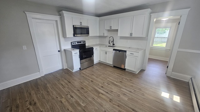 82 Windsor St, Enfield, CT 06082 - kitchen with appliances with stainless steel finishes, a baseboard radiator, white cabinetry, and dark wood-type flooring