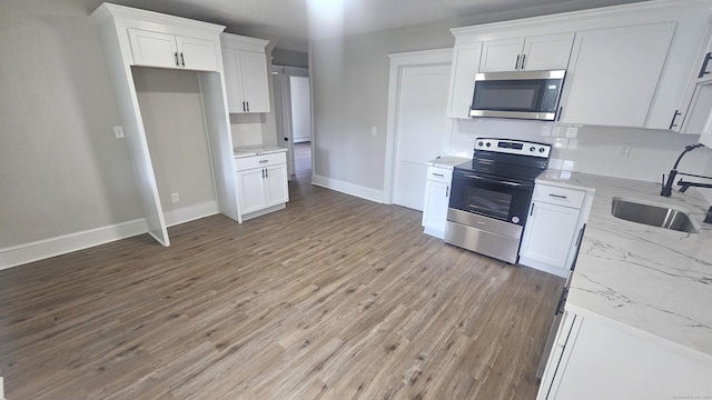 82 Windsor St, Enfield, CT 06082 - kitchen featuring appliances with stainless steel finishes, white cabinets, a sink, backsplash, and light stone counters