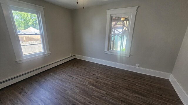 82 Windsor St, Enfield, CT 06082 - empty room with a baseboard radiator, dark wood-type flooring, healthy amount of natural light, and baseboards