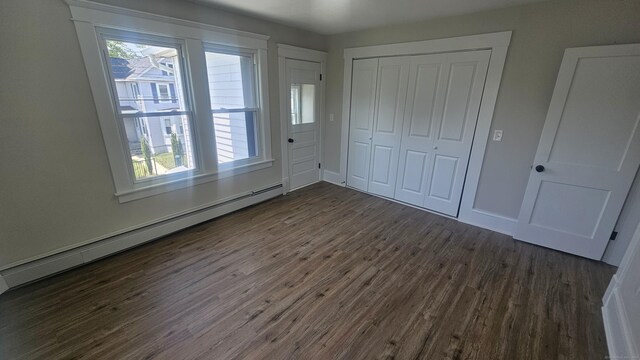 82 Windsor St, Enfield, CT 06082 - unfurnished bedroom with a baseboard radiator, dark wood finished floors, a closet, and baseboards