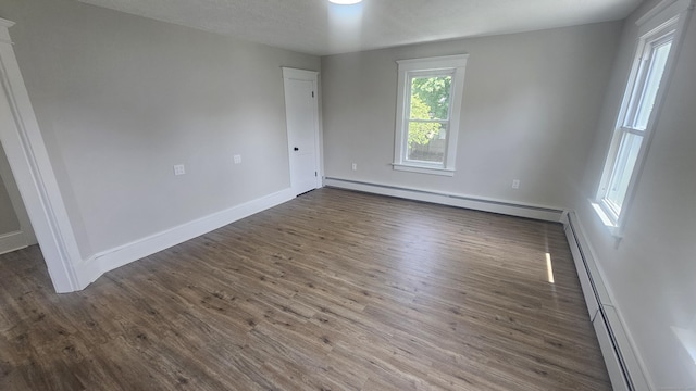 82 Windsor St, Enfield, CT 06082 - empty room with a baseboard heating unit, dark wood-style flooring, and baseboards