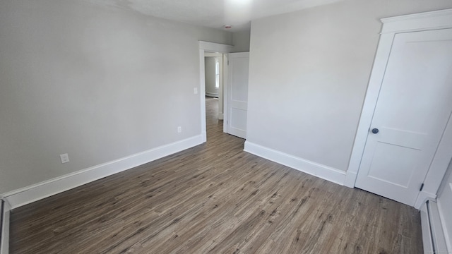 82 Windsor St, Enfield, CT 06082 - unfurnished bedroom featuring wood finished floors, baseboards, and a baseboard heating unit