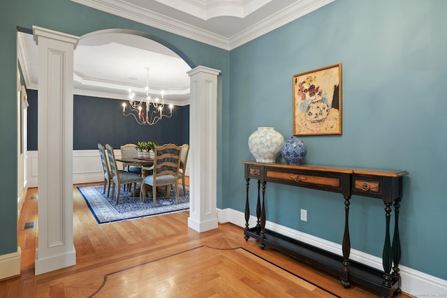 36 Fox Mdw, Marlborough, CT 06447 - dining room with ornate columns, crown molding, arched walkways, a chandelier, and baseboards