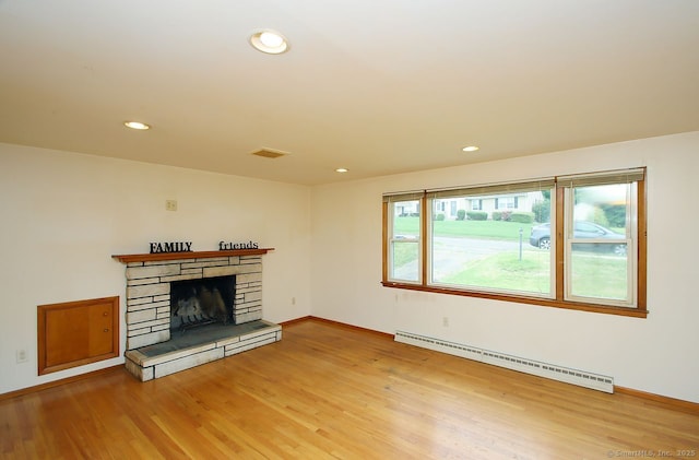 65 Bayberry Dr, Wallingford, CT 06492 - unfurnished living room with a baseboard heating unit, wood finished floors, recessed lighting, baseboards, and a stone fireplace