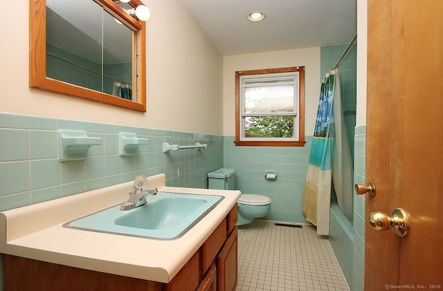 65 Bayberry Dr, Wallingford, CT 06492 - full bath with tile walls, toilet, vanity, shower / tub combo with curtain, and wainscoting