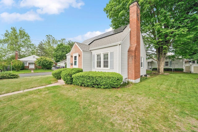 151 Mckee St, Manchester, CT 06040 - view of home's exterior with solar panels, a yard, a chimney, and a shingled roof