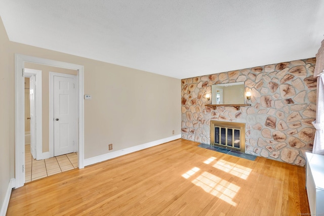 151 Mckee St, Manchester, CT 06040 - unfurnished living room featuring wood finished floors, a stone fireplace, and baseboards