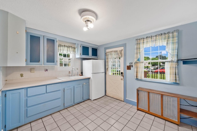 151 Mckee St, Manchester, CT 06040 - kitchen with freestanding refrigerator, a sink, blue cabinetry, and radiator heating unit