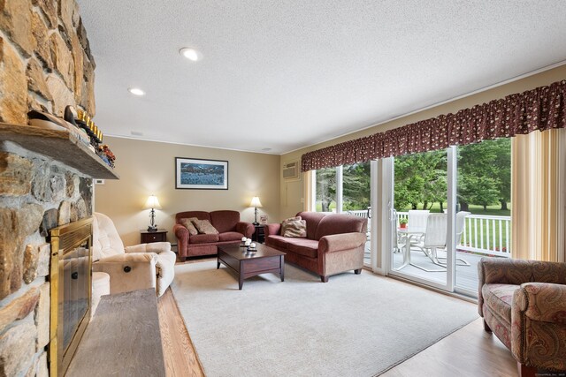 176 Prospect Hill Rd, Colchester, CT 06415 - living room with a stone fireplace, a textured ceiling, wood finished floors, and recessed lighting