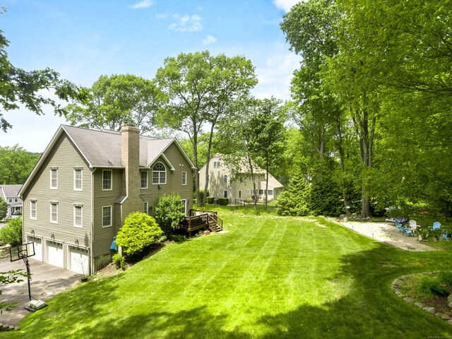 67 Melissa Ln, Prospect, CT 06712 - view of side of property with a garage, a chimney, concrete driveway, and a yard
