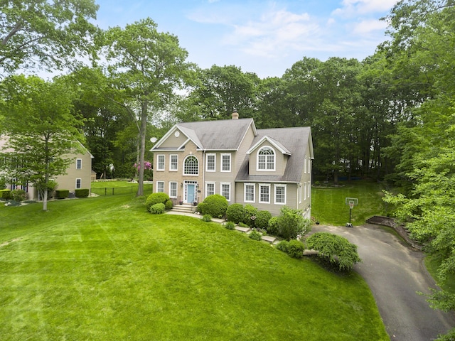 67 Melissa Ln, Prospect, CT 06712 - colonial house featuring a front lawn, a chimney, view of scattered trees, and asphalt driveway