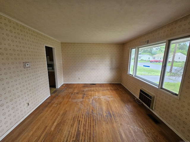 30 Hardwood Rd, Plainville, CT 06062 - spare room with hardwood / wood-style floors, wallpapered walls, baseboards, and an AC wall unit