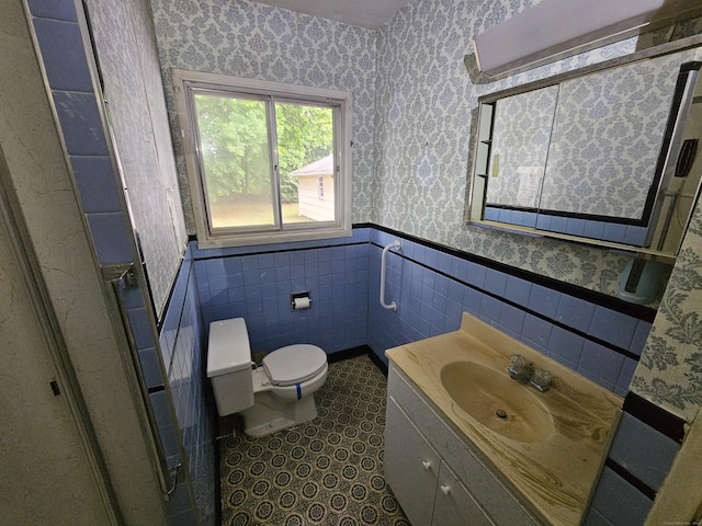 30 Hardwood Rd, Plainville, CT 06062 - bathroom with wallpapered walls, a wainscoted wall, toilet, vanity, and tile walls