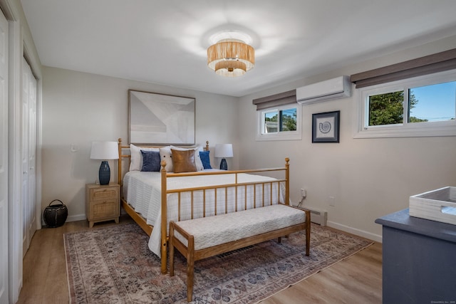 35 Soundview Ave, Old Saybrook, CT 06475 - bedroom with a wall mounted AC, wood finished floors, baseboards, and a baseboard radiator