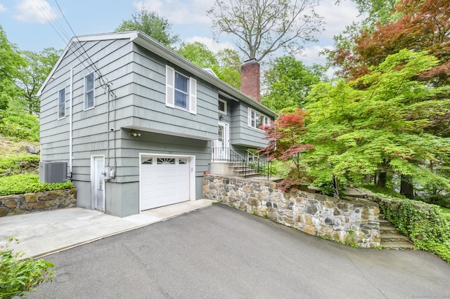 525 Bennetts Farm Rd, Ridgefield, CT 06877 - view of front of home featuring a chimney, cooling unit, an attached garage, and driveway