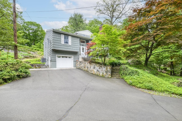 525 Bennetts Farm Rd, Ridgefield, CT 06877 - view of home's exterior featuring driveway, a garage, a chimney, and stairway