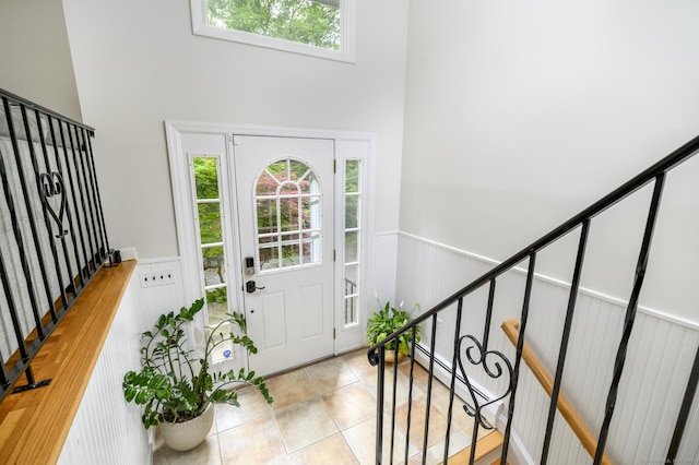 525 Bennetts Farm Rd, Ridgefield, CT 06877 - tiled entryway with wainscoting, a high ceiling, stairway, and a baseboard radiator