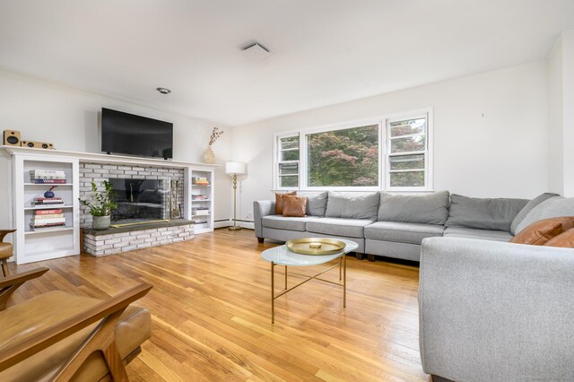 525 Bennetts Farm Rd, Ridgefield, CT 06877 - living area featuring wood finished floors, a brick fireplace, and a baseboard heating unit