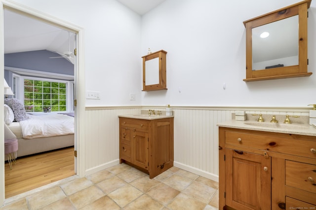 525 Bennetts Farm Rd, Ridgefield, CT 06877 - ensuite bathroom featuring two vanities, a ceiling fan, a wainscoted wall, and lofted ceiling