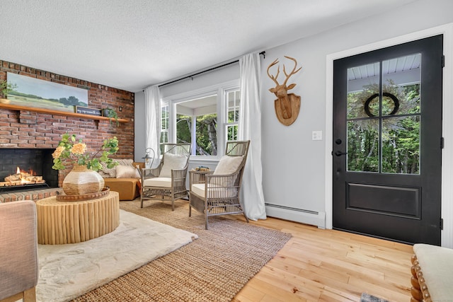 53 Pratt Rd, Plainfield, CT 06374 - entryway featuring a baseboard heating unit, hardwood / wood-style flooring, a fireplace, and a textured ceiling