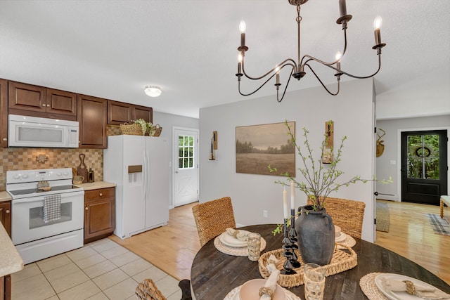 53 Pratt Rd, Plainfield, CT 06374 - kitchen with white appliances, light countertops, decorative backsplash, a chandelier, and light wood-style flooring