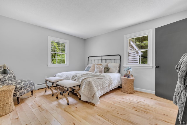 53 Pratt Rd, Plainfield, CT 06374 - bedroom with multiple windows, hardwood / wood-style flooring, baseboards, and a baseboard heating unit
