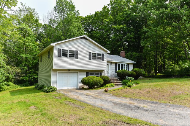 10 Meeting House Rd, Barkhamsted, CT 06063 - tri-level home with asphalt driveway, a chimney, a front lawn, and an attached garage