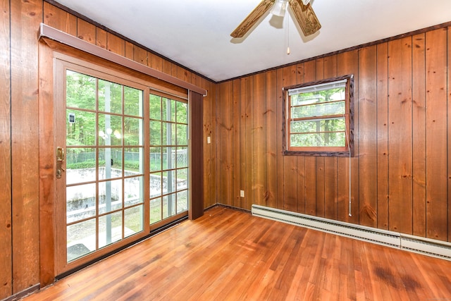 10 Meeting House Rd, Barkhamsted, CT 06063 - spare room featuring baseboard heating, hardwood / wood-style floors, wood walls, and ceiling fan