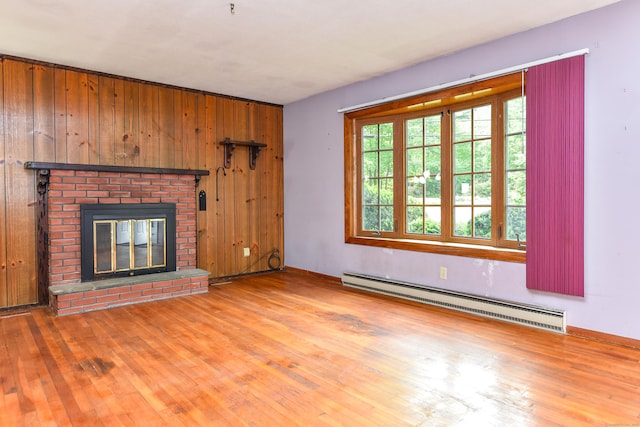 10 Meeting House Rd, Barkhamsted, CT 06063 - unfurnished living room with a baseboard heating unit, wood finished floors, wood walls, a brick fireplace, and baseboards
