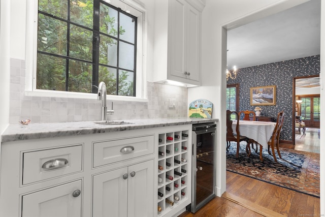 20 Cook Rd, Stamford, CT 06902 - bar area featuring wallpapered walls, wine cooler, a sink, dark wood-style floors, and a chandelier
