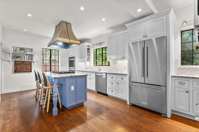 20 Cook Rd, Stamford, CT 06902 - kitchen with appliances with stainless steel finishes, a center island, dark wood-style floors, decorative backsplash, and white cabinets